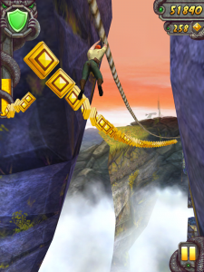 Screenshot fra Temple Run 2 - helten kører langs en svævebane og samler mønter